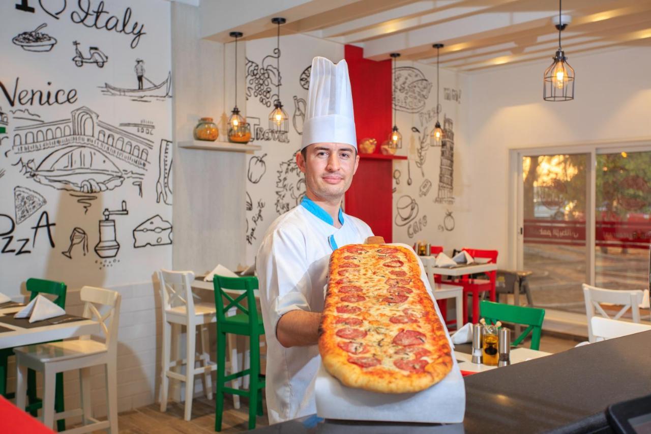 Sealine Beach, A Murwab Resort Mesaieed Exteriör bild A pizzaiolo with a metre-long pizza
